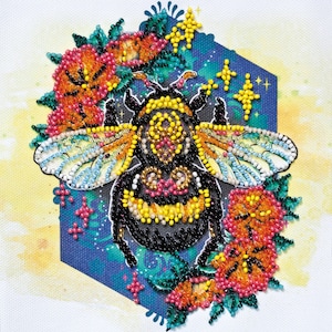 May include: A colorful beaded bumble bee with black and yellow stripes surrounded by flowers and stars on a blue background.