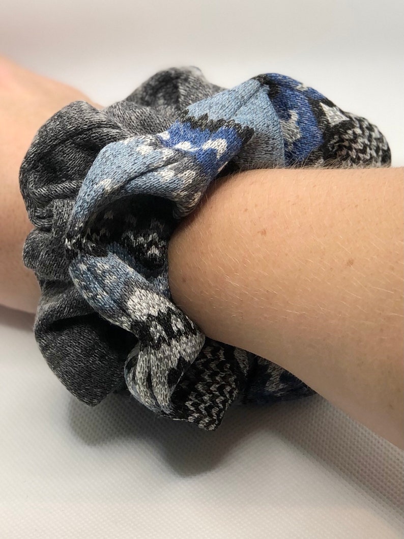 May include: A gray and blue patterned scrunchie made of fabric.