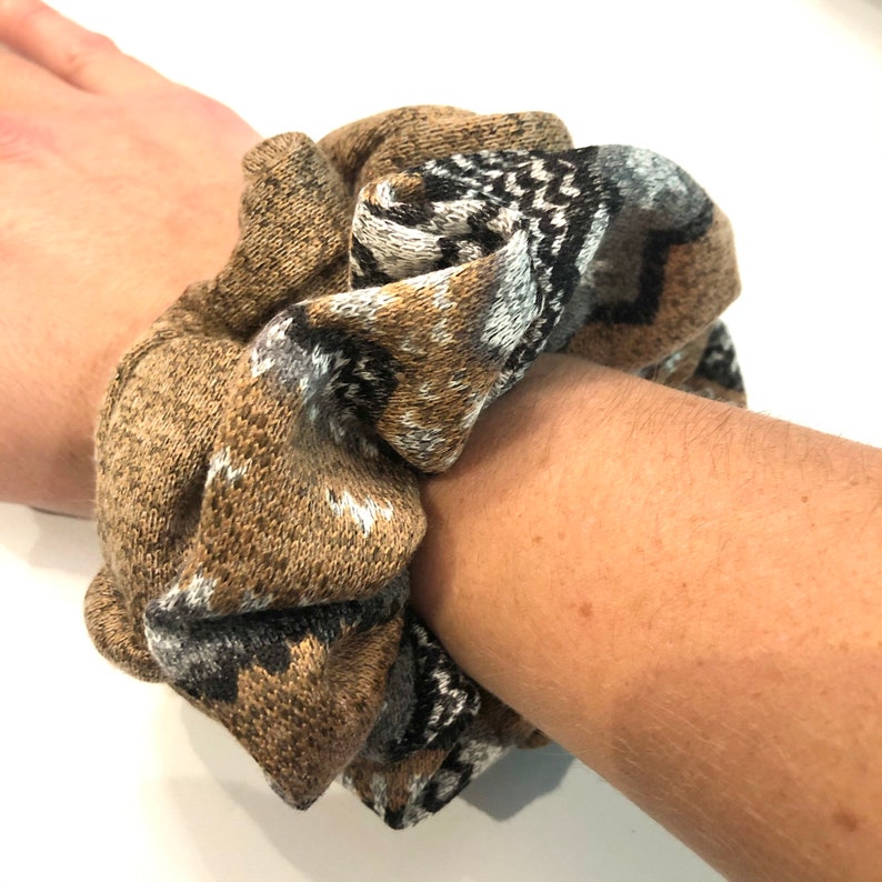 May include: A brown and gray patterned scrunchie made of knitted fabric.