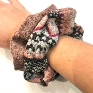 May include: A pink and gray patterned scrunchie with a black and white geometric design.