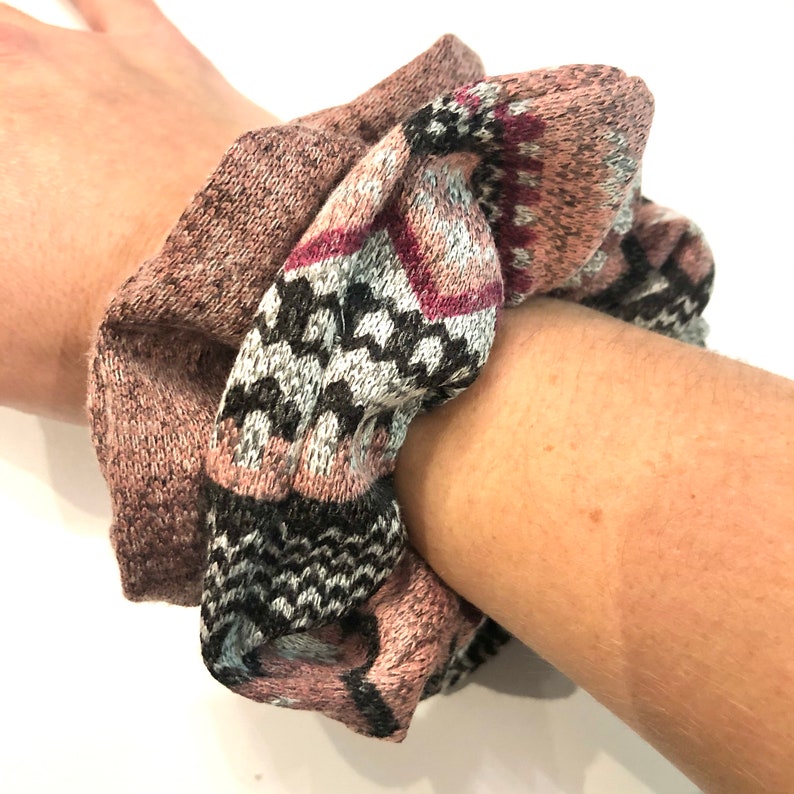May include: A pink and gray patterned scrunchie with a black and white geometric design.