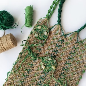 Peut inclure: Un sac fourre-tout en crochet vert et marron avec du fil vert et une pelote de ficelle brune. Le sac a un design tissé et est décoré de perles vertes et blanches.