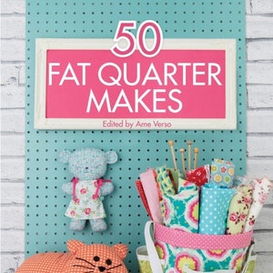 May include: A book titled "50 Fat Quarter Makes" with a pink cover and white frame. The book is on a turquoise background with white polka dots. The book title is in white text. The book is about sewing projects made using fat quarters.
