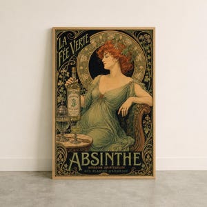 Könnte beinhalten: Ein Poster im Vintage-Stil mit einer rothaarigen Figur in einem fließenden grünen Kleid, die in einem Sessel sitzt. Der Text lautet LA FEE VERTE und ABSINTHE BOISSON SPIRITUEUSE AUX PLANTES D'ABSINTHE. Eine Flasche und ein Glas stehen auf einem Tisch.