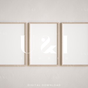 May include: Three framed prints with the letters "U", "&", and "I" in a modern, minimalist style. The frames are light wood and the letters are white against a white background.