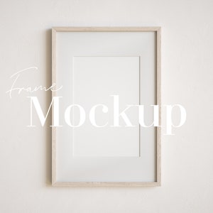 Peut inclure: Une maquette de cadre en bois clair simple sur un mur blanc. Le cadre est vide et pr&ecirc;t pour votre design.