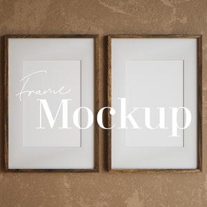 Puede incluir: Dos marcos de fotos de madera marrón con paspartú blanco y bordes blancos. Los marcos están colgados en una pared marrón texturizada. El texto "Frame Mockup" está escrito en blanco en el centro de la imagen.
