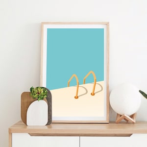 May include: A framed print of a minimalist illustration of a swimming pool with two yellow ladder rungs. The background is a light blue color and the pool is white.