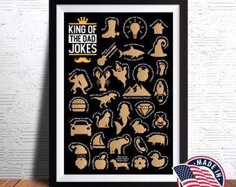Puede incluir: Un póster enmarcado en negro con letras doradas que dice "King of the Dad Jokes". El póster tiene una variedad de iconos e ilustraciones doradas, incluyendo una corona, una bombilla, una langosta, un dinosaurio, una sirena, una abeja, un pato y una manzana. El póster está hecho en los Estados Unidos.