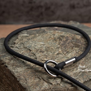 close up of a black slip lead with silver hardware laying on a rock