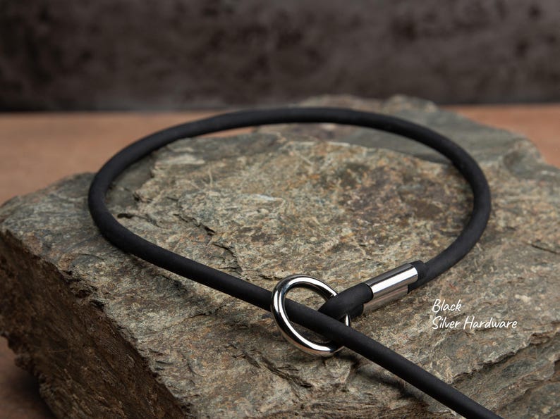 close up of a black slip lead with silver hardware laying on a rock