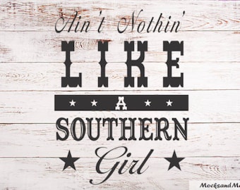 May include: White wooden sign with black text that reads "Ain't Nothin' LIKE A SOUTHERN Girl" with two stars on either side of the word "Girl".
