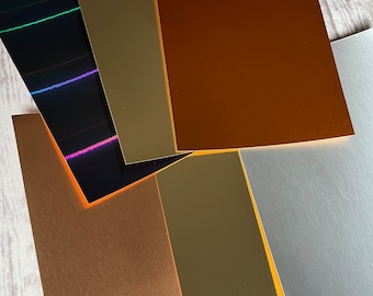 May include: Assortment of six metallic cardstock sheets in various colors, including gold, copper, silver, and black. The sheets have a smooth, metallic finish and are perfect for crafting and scrapbooking.