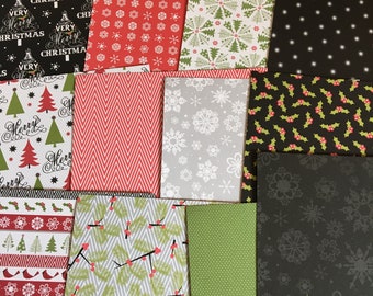 May include: A collection of 15 Christmas themed patterned paper sheets in various colors, including red, green, black, and white. The patterns include snowflakes, trees, holly, and the words "Merry Christmas".