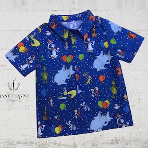 May include: A blue short-sleeved button-up shirt with a colorful print of characters and balloons. The print features characters from the book "The Cat in the Hat".