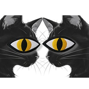 May include: A symmetrical image of two black cat profiles facing each other. Each cat has a large, embroidered eye patch with a white border and a yellow iris. The cats' fur is detailed, and white whiskers are visible.