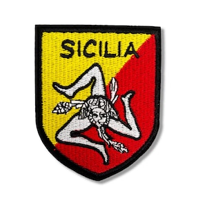 May include: A red and yellow embroidered patch with the word "SICILIA" and a white stylized image of a triskelion, a three-legged figure, on a black background.