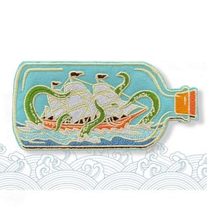 May include: Embroidered patch depicting a ship and a sea monster inside a light blue bottle. The ship has white sails and an orange hull. Green tentacles wrap around the ship. The bottle has an orange stopper.