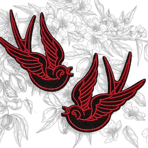 Könnte beinhalten: Zwei aufgestickte Aufnäher mit einem Schwalben-Design. Die Schwalben sind schwarz mit roten Details an Flügeln und Schwanz. Der Hintergrund ist eine floralen Illustration in Graustufen.