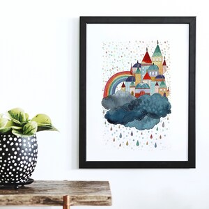 May include: A colorful illustration of a rainbow over a cloud with a whimsical castle on top. The castle has multiple towers and windows, and the cloud is a dark blue with white stitching. Rain drops fall from the cloud in various colors.