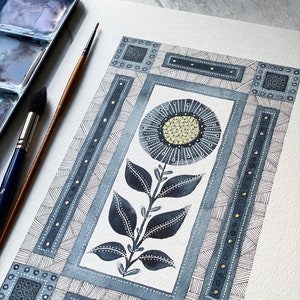 May include: A watercolor painting of a stylized flower with blue and gold accents. The flower is surrounded by a geometric pattern of squares and lines.