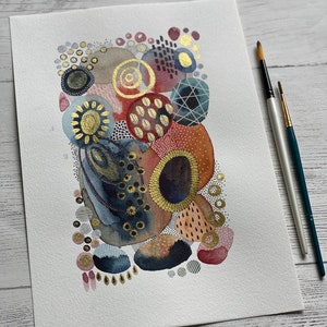 May include: Abstract watercolor painting with gold accents. The painting features a variety of shapes and patterns in shades of red, brown, blue, and gray.