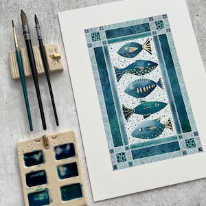 May include: A watercolor painting of five blue fish with gold accents, framed in a blue and white geometric pattern.