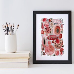May include: A framed abstract watercolor painting with pink, red, and gold shapes on a white background. The painting is in a black frame.