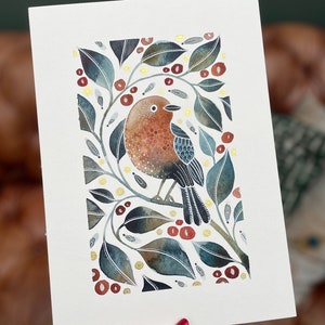 May include: Watercolor painting of a bird with brown, red, and blue feathers perched on a branch with green leaves and gold accents.
