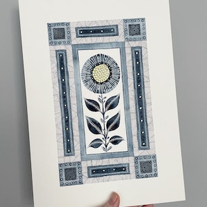 May include: A watercolor painting of a stylized flower with blue and yellow accents. The flower is surrounded by a geometric frame with black and white lines and dots.