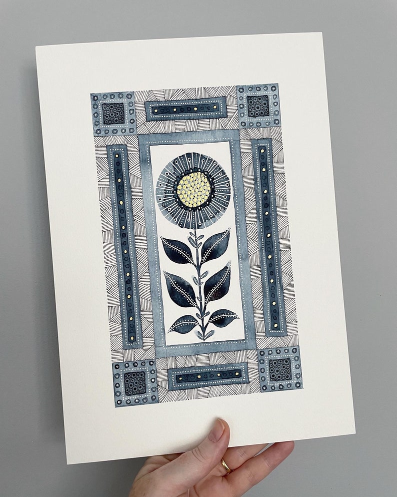 May include: A watercolor painting of a stylized flower with blue and yellow accents. The flower is surrounded by a geometric frame with black and white lines and dots.