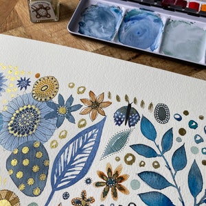 May include: A watercolor painting of a floral design with blue, gold, and brown accents. The painting features leaves, flowers, and dots. The painting is on a white background.
