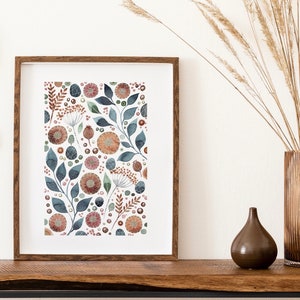 May include: A framed print with a watercolor floral pattern. The print features a repeating pattern of blue, green, and orange flowers, leaves, and berries on a white background.