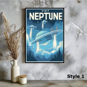 May include: A framed poster with a retro-style illustration of flying saucers over a planet, with the text "VISIT NEPTUNE" in white. The artwork features a blue and teal color scheme, with stylized mountains and clouds.