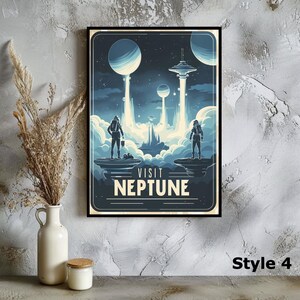 May include: A framed art print with a retro space travel theme. The artwork features two astronauts on a planet, with the text "VISIT NEPTUNE" below. The color palette is primarily blue and white, with a vintage poster style.
