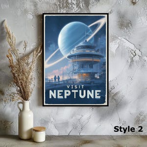 Puede incluir: Un p&oacute;ster enmarcado con un tema de viaje retro, que presenta un edificio futurista y el texto "VISIT NEPTUNE". La obra de arte representa un planeta con anillos en una combinaci&oacute;n de colores azul y blanco. El p&oacute;ster est&aacute; etiquetado como "Estilo 2".