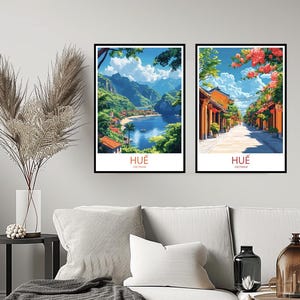 May include: Two framed prints of Hue, Vietnam. The first print shows a scenic view of a bay with lush green mountains in the background. The second print shows a street lined with orange buildings and pink flowers.
