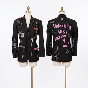 May include: Two black pinstriped blazers displayed on mannequins. The front features attached metal keys, patches, and the text "Do Good" and "Let your light shine". The back features the text "Unlocking His purpose 4 me!" in pink paint.