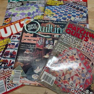 May include: A collection of vintage quilting magazines with colorful covers. Titles include "Quilt," "Quick & Easy Quilting," and "Lady's Circle Patchwork Quilts." The magazines feature quilting projects, patterns, and techniques for quilters of all levels.