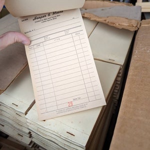 May include: A white sales receipt with the text "Hooper & Moore" and "Clothes for Men and Young Men Ladies Sports Wear" printed at the top. The receipt has columns for department, code, item, and price. The sales tax is listed as 29 cents.