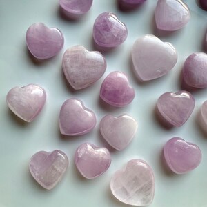 Close-up of mini Pink Kunzite hearts on a white background — crystal hearts for peace, compassion & energetic balance.