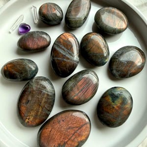 Collection of Peachy Sunset Labradorite palm stones with glowing orange and apricot labradorescence