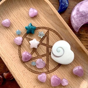 Wooden tray with assorted celestial crystals, featuring mostly Mini Pink Kunzite hearts — sweet pink stones for emotional healing & spiritual connection.