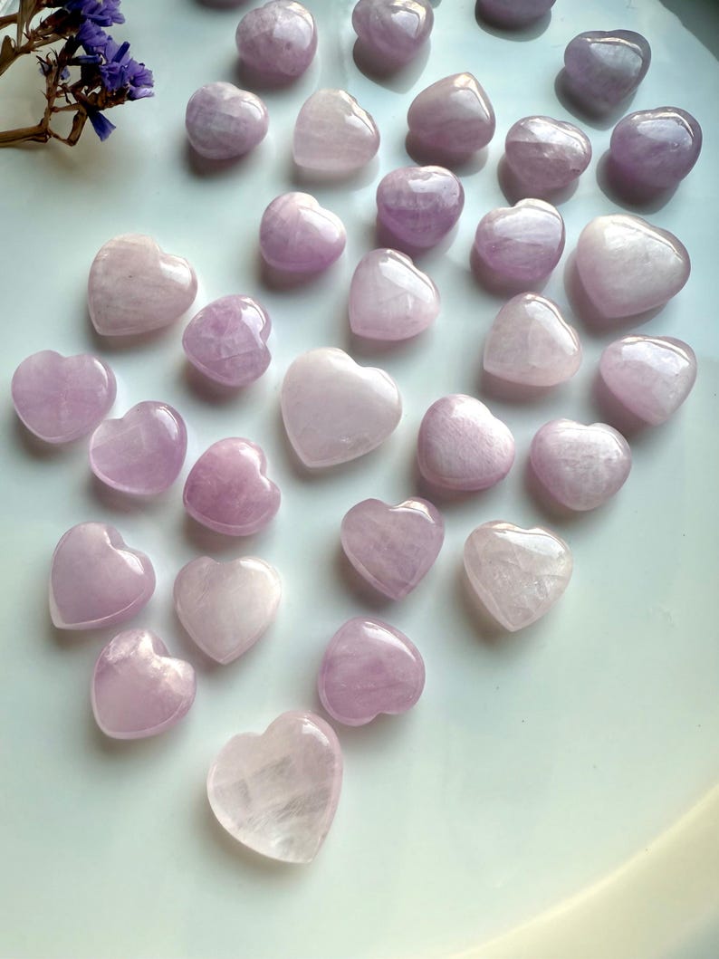Angled view of Pink Kunzite crystal hearts on white — soothing heart chakra stones for emotional support & spiritual healing.