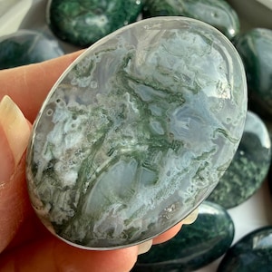 Moss agate palm stone close view showing smooth polish and comfortable palm stone shape for meditation and grounding