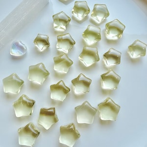 Mini Lemon Citrine stars in two sizes showing their clear, translucent lemon-yellow color