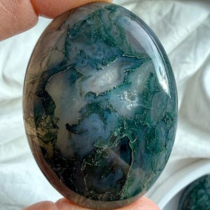 Natural moss agate palm stone with forest-like inclusions and soft green tones, calming crystal for emotional balance