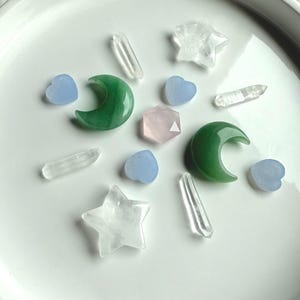 Crystal grid with Clear Quartz stars, Green Aventurine moons, Blue Chalcedony hearts, quartz points, and Rose Quartz hexagon in center, sacred geometry layout for heart chakra healing