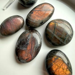 Peachy orange Labradorite palm stones with sunset flash and charcoal gray base