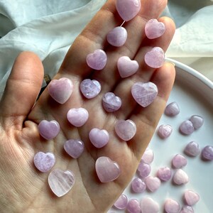 Handful of Mini Kunzite Hearts showing size and color variation – pink and lavender kunzite for emotional healing and heart chakra support